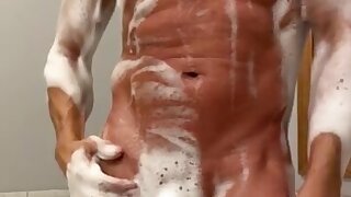 Slow motion daddy removes soap revealing his shaved chiseled body